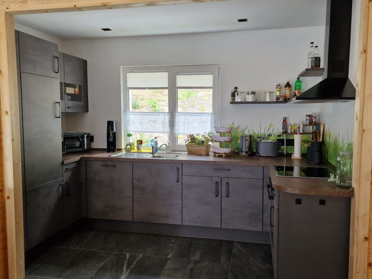 Ferienhaus Küche mit Kühlschrank, Herd, Ofen, Arbeitsplatte und Spüle